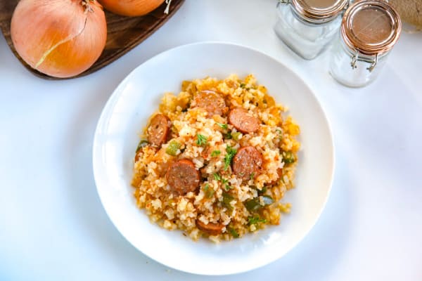 This cajun cauliflower rice is a paleo, whole30, and keto take on dirty rice. It uses riced cauliflower, andouille sausage, pepper, onion and creole and cajun seasonings to make an easy one pot skillet meal. #whole30 #paleo #keto