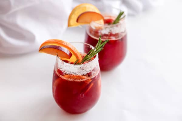 christmas punch in a glass with fruit and a sugar rim.