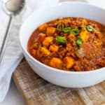 Chili in a bowl next to a spoon