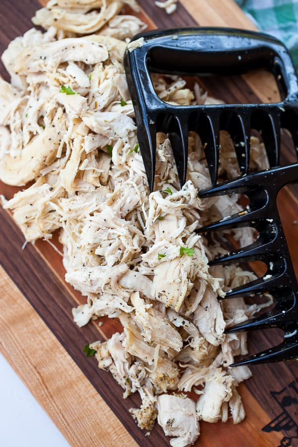 all purpose shredded chicken on a wooden cutting board