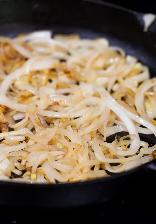 onions cooking in a cast iron skillet