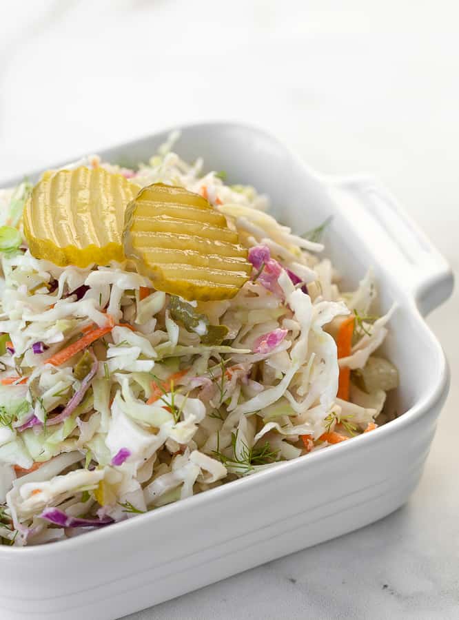 dill pickle coleslaw in a white dish