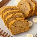 pumpkin banana bread sliced on a pan with bananas