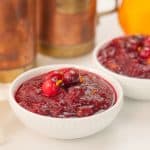 cranberry sauce in a white dish garnished with raw cranberries