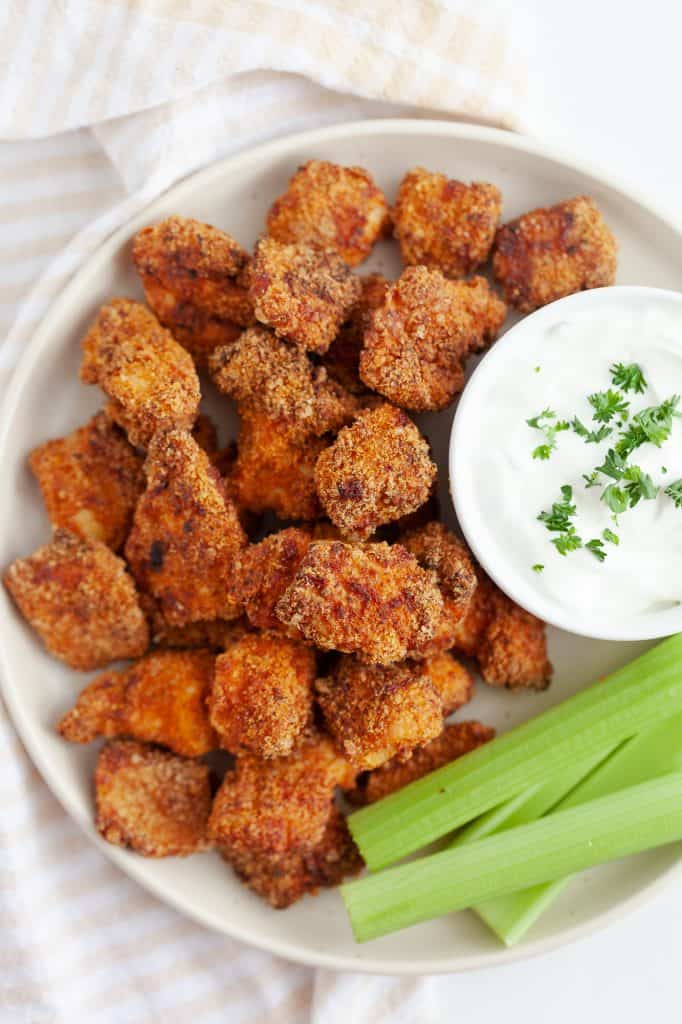 Keto Buffalo Popcorn Chicken and dipping sauce on a white plate