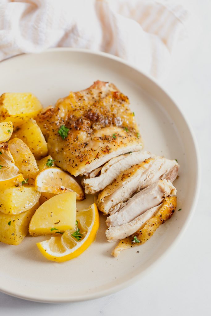 sliced chicken thighs with potatoes and lemon