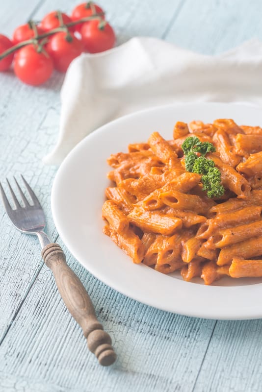 penne with vodka on a plate with a fork