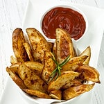 potato wedges in a dish with ketchup