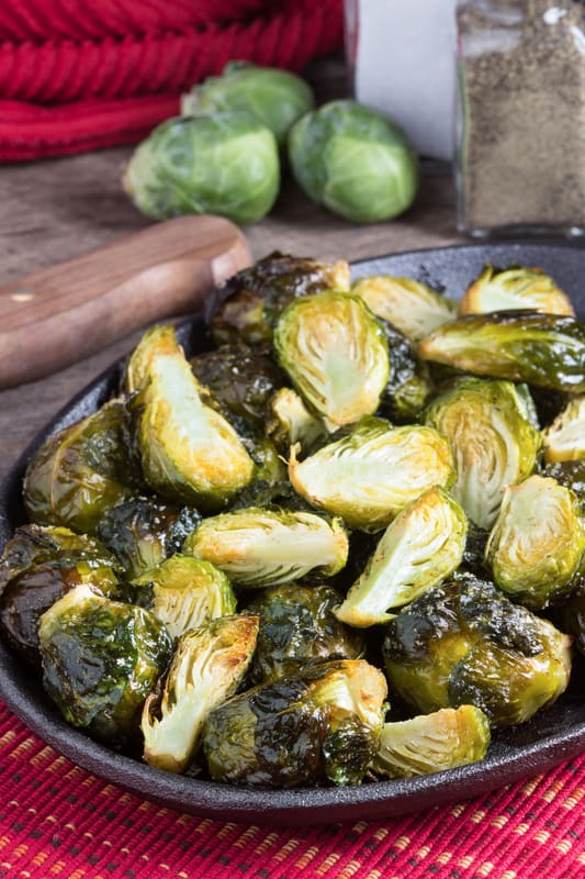 brussels sprouts in a cast iron pan on a red table cloth