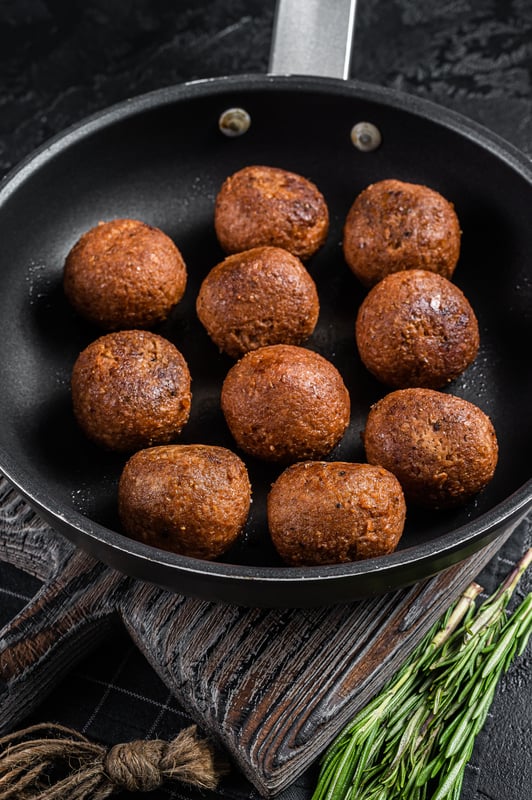 air fryer beyond meatballs in a pan on a wooden cutting board