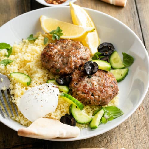 lamb burgers on a plate with vegetables