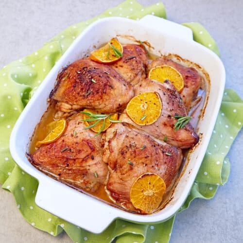 turkey thighs in a baking dish with oranges