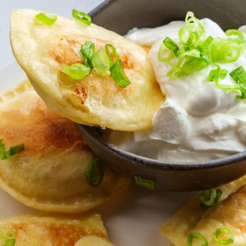 cooked pierogi dipped in sour cream