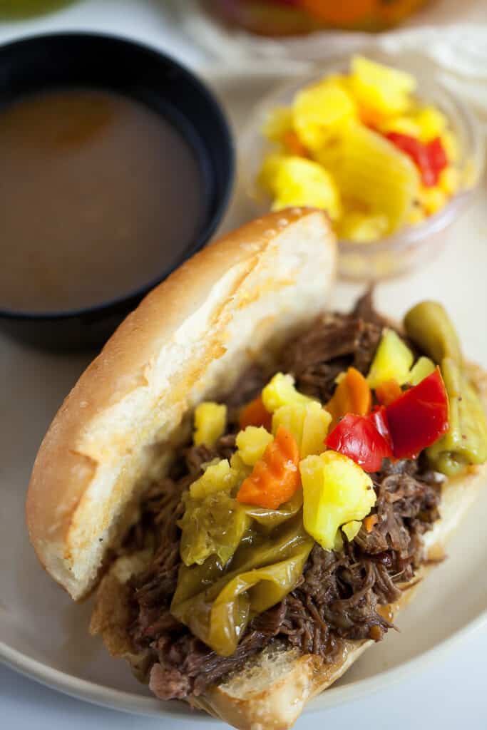 italian beef sandwich on a plate with au jus