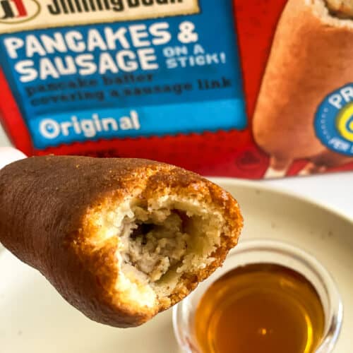 close up of a cooked jimmy dean pancakes and sausage on a stick with syrup.