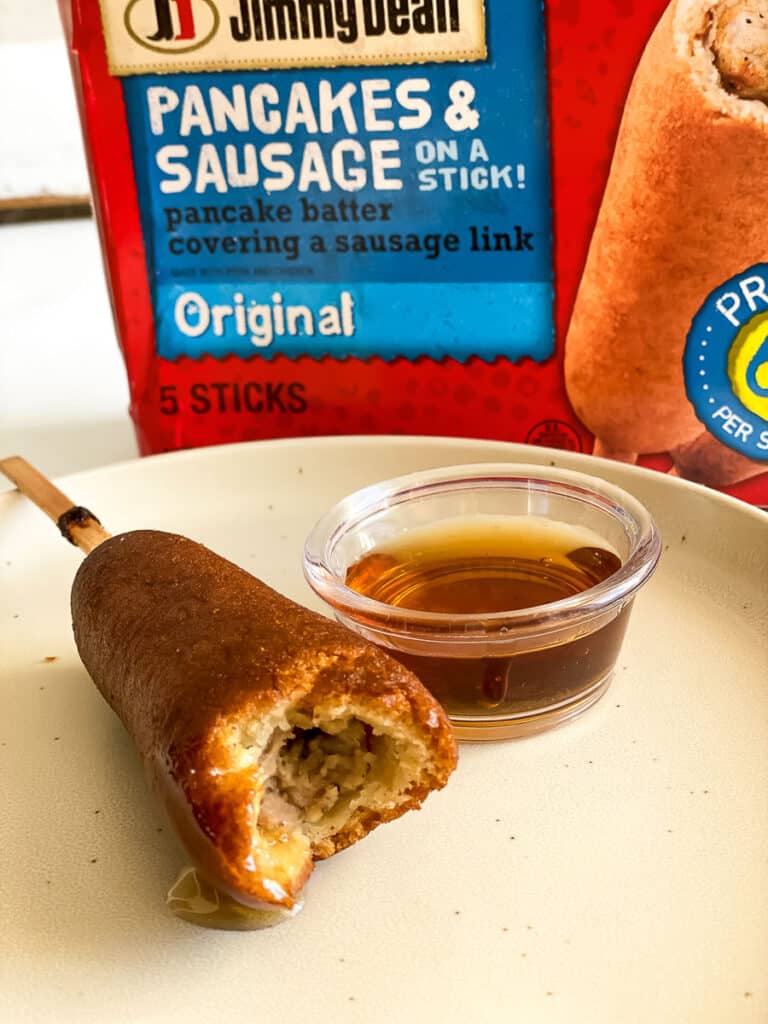 jimmy dean pancakes and sausage on a stick on a plate with syrup