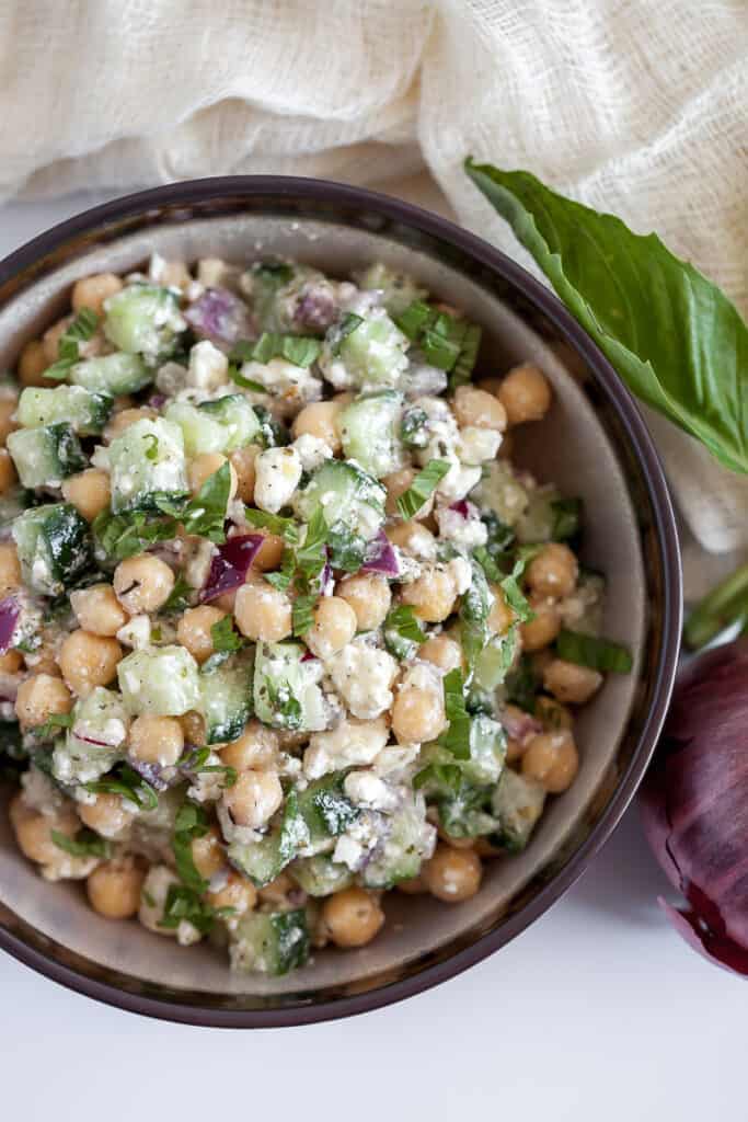 salad in a bowl with chickpeas, cucumbers, and feta cheese