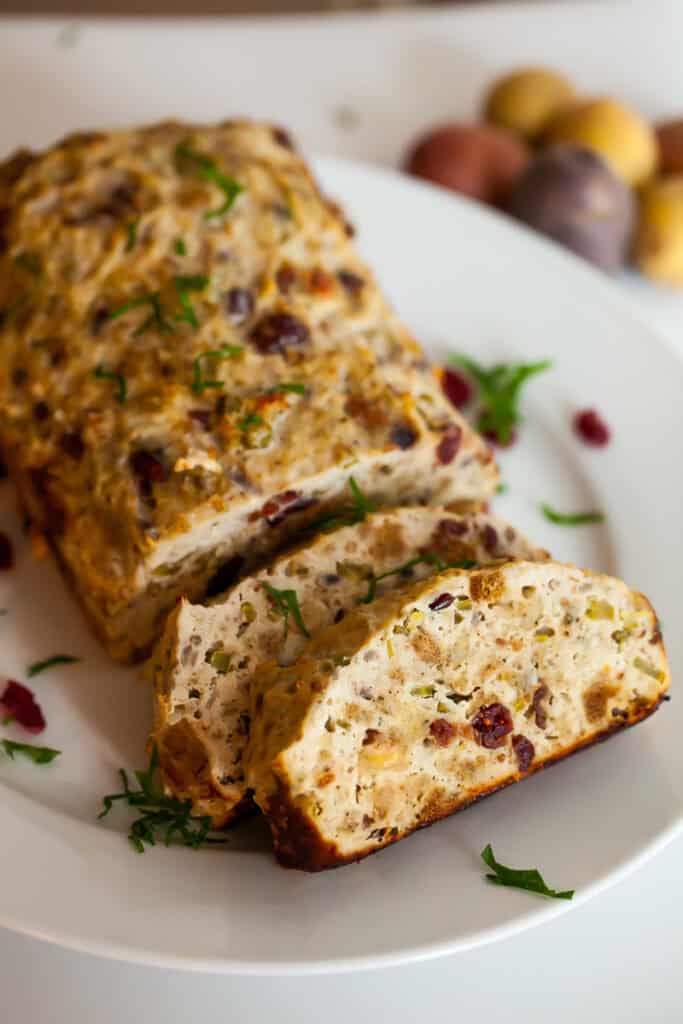 chicken meatloaf sliced on a plate with cranberries and stuffing