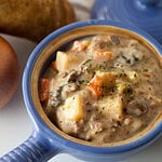 potato and hamburger soup in a blue crock
