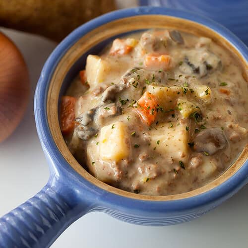 potato and hamburger soup in a blue crock