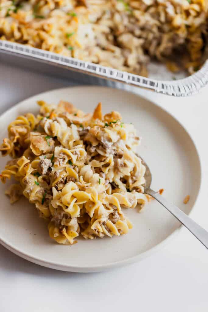 french onion pasta bake on a plate with a spoon with the casserole in the background