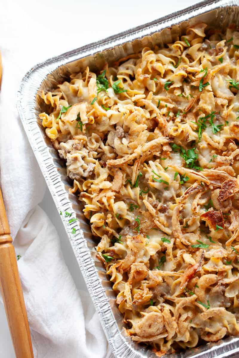 a casserole tray of pasta bake with ground beef, onions, and a creamy sauce