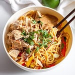 chicken with sesame peanut noodles in a bowl with chopsticks