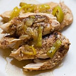 shredded chicken breast with peppers and onions on top